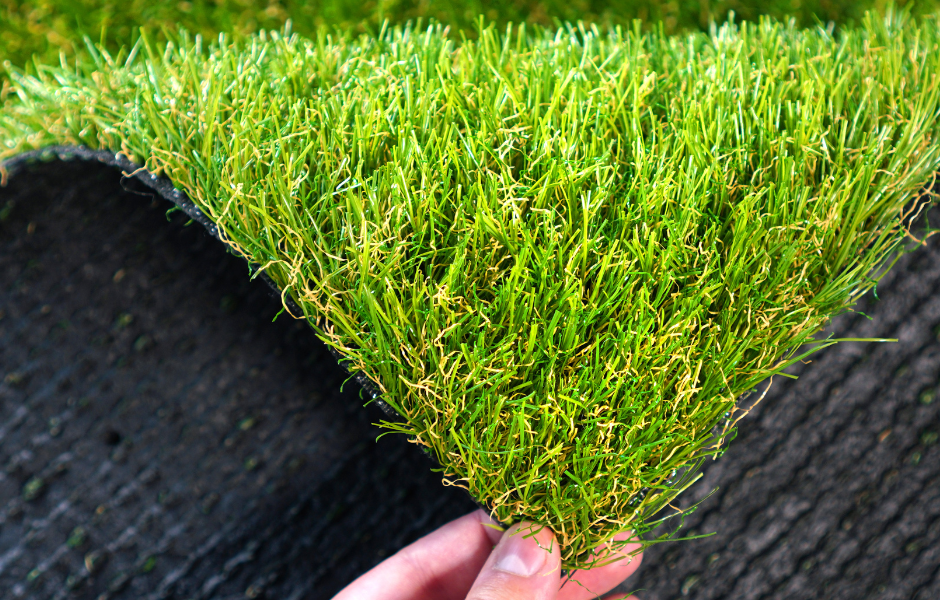 Persona tocando el césped artificial de la alfombra para ver si está en buenas condiciones
