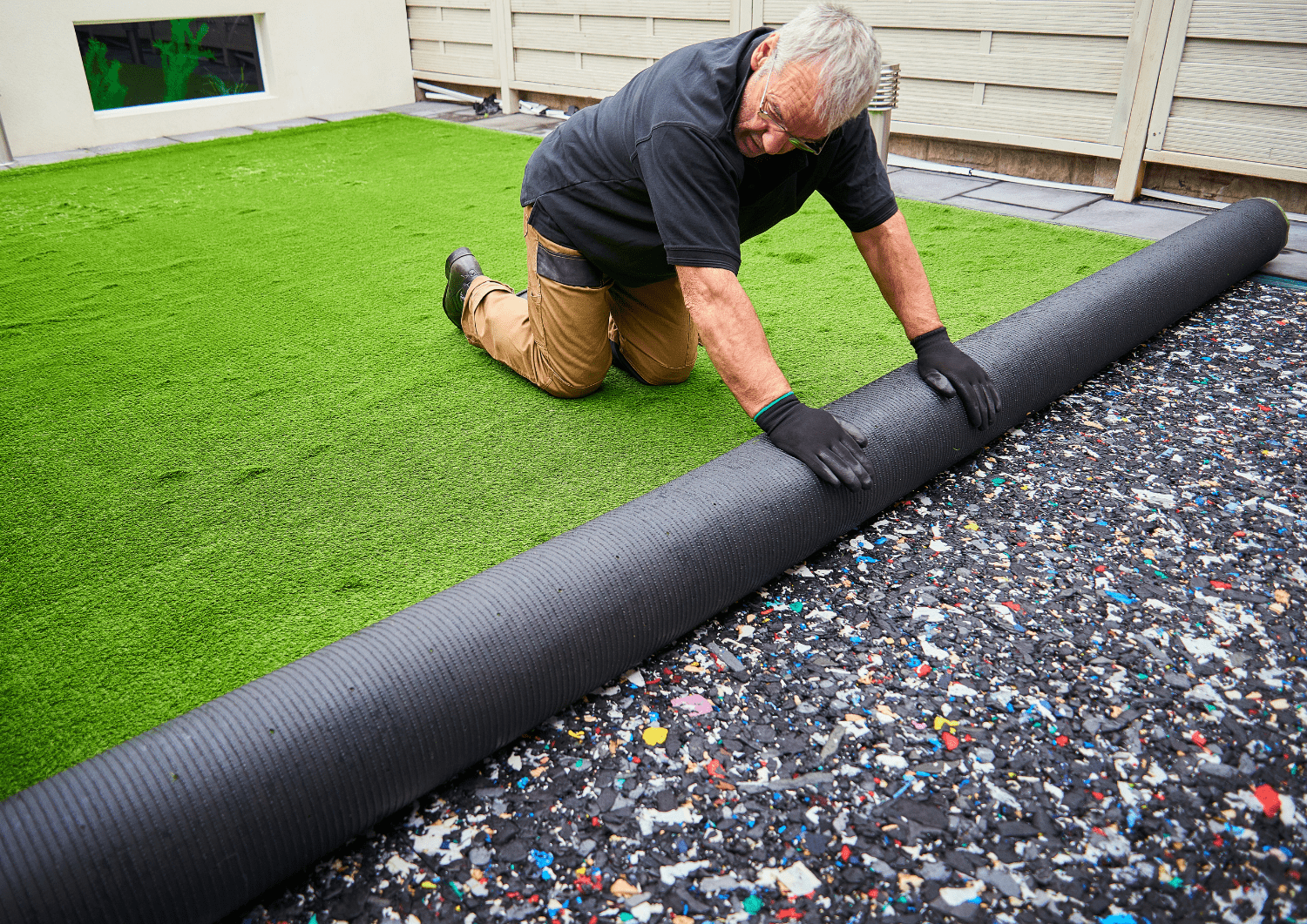 Trabajador colocando césped artificial en casa con patio de Girona